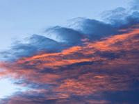 Bergspitze mit rötlicher Wolkenfront darüber
